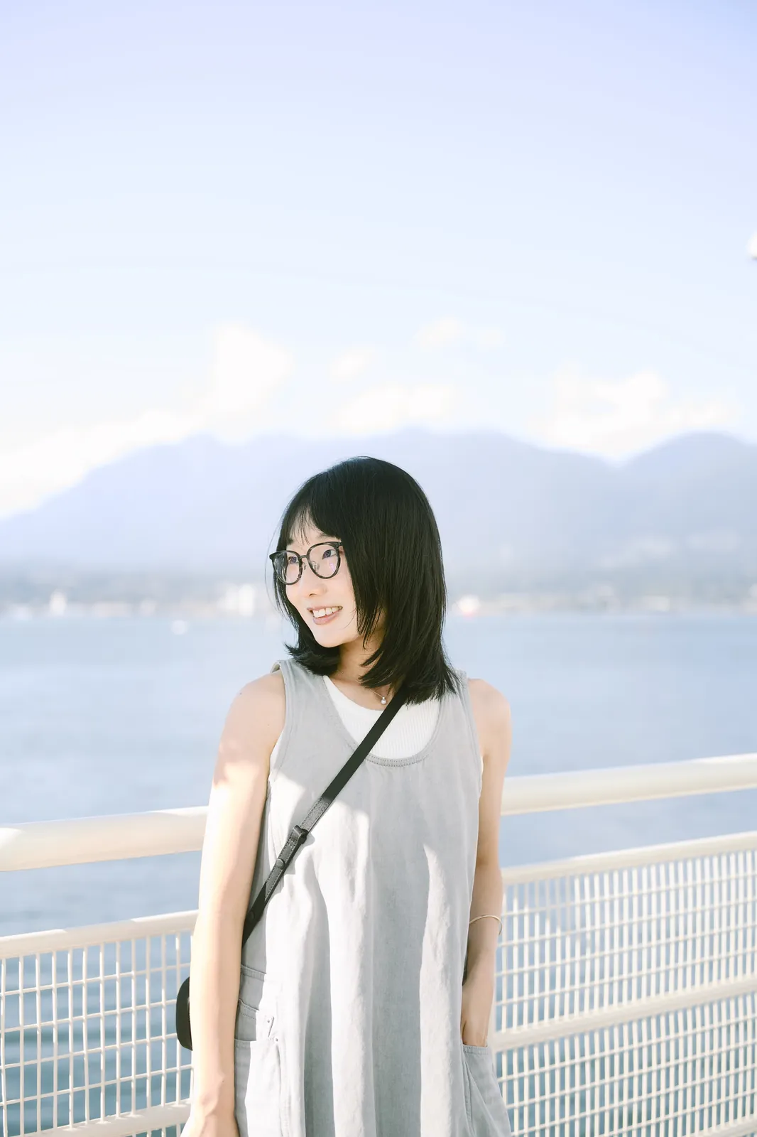Waterfront portrait of a girl with glasses in front of beautiful scenic mountains and water, outdoor Seattle lifestyle shoot