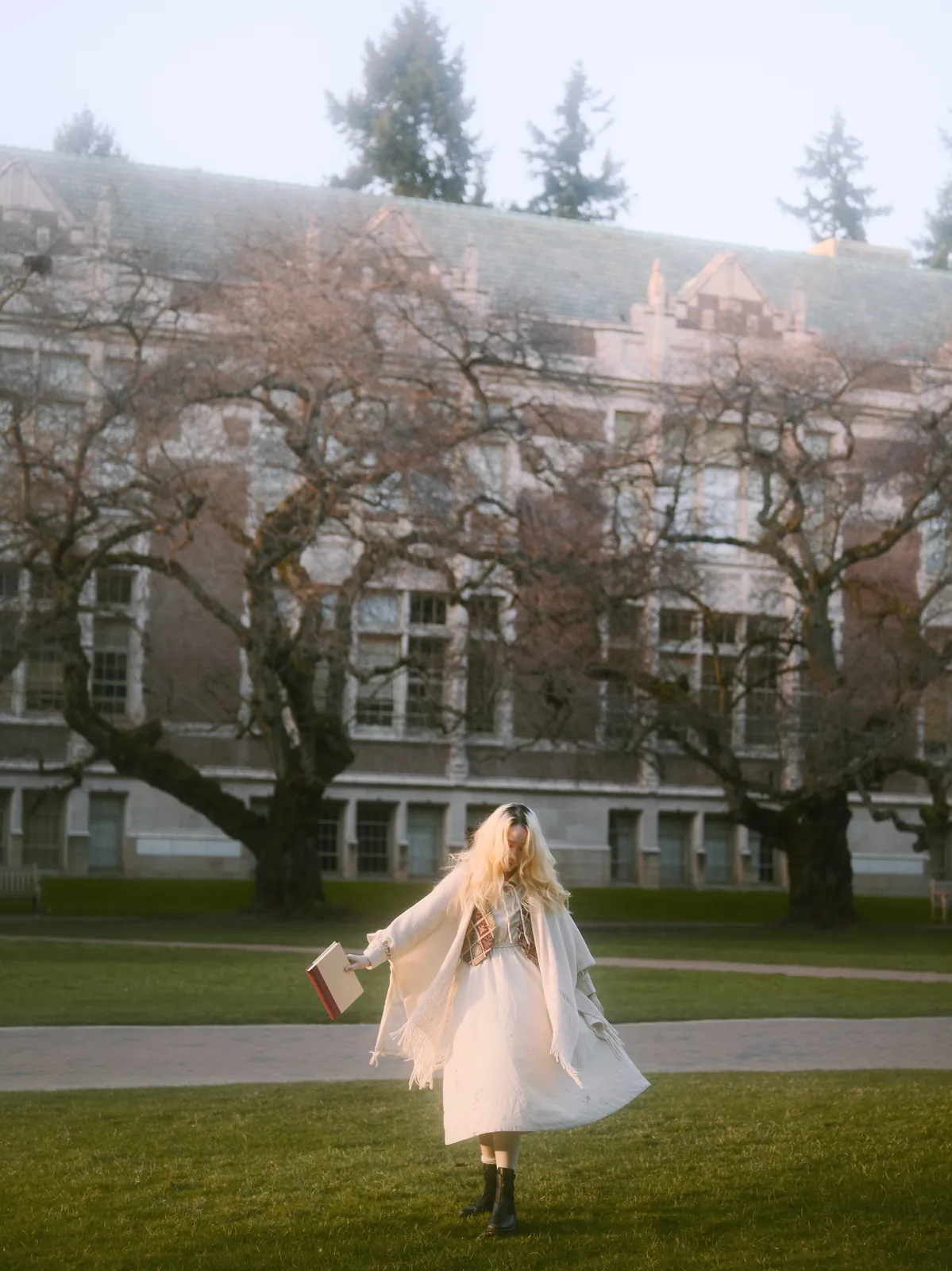 Dreamy motion-blur portrait of a girl spinning in white dress in front of UW gothic architecture at the Quad