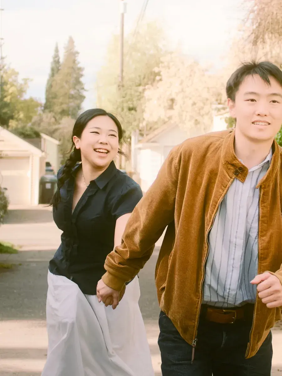 Couple moving hand in hand along a shaded Seattle neighborhood path