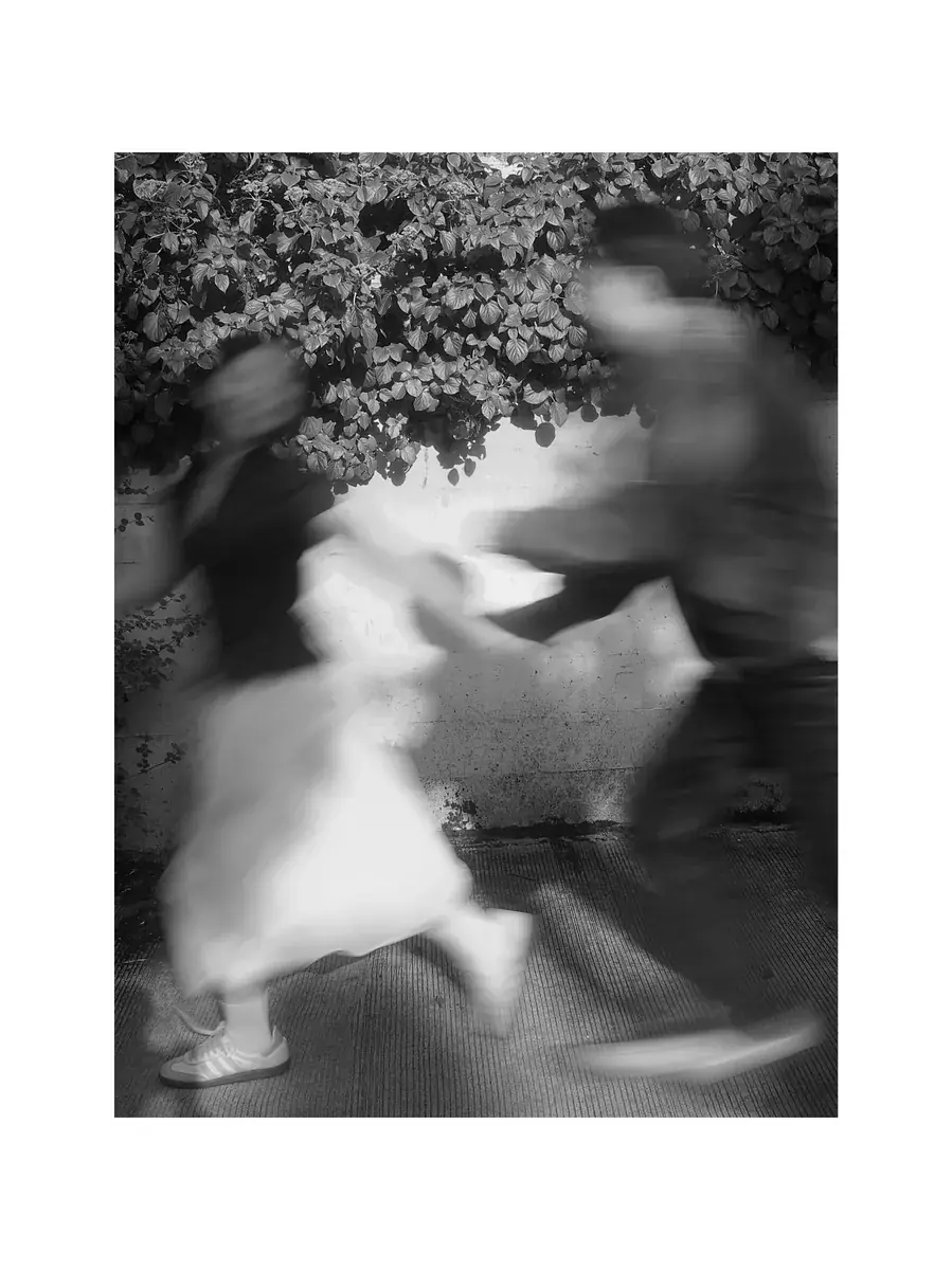 Artistic black-and-white motion blur of a couple running together