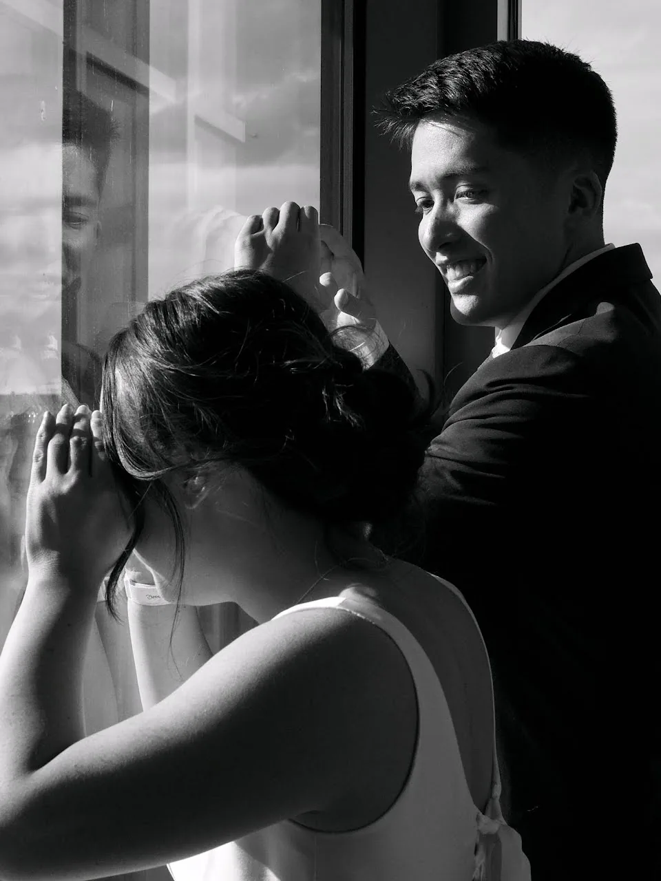 Candid couple portrait by the large courthouse window overlooking Seattle skyline