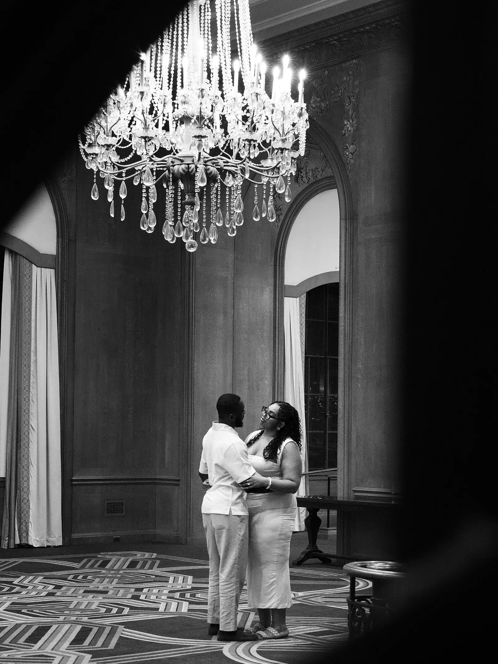 Couple standing together beneath a chandelier at Seattle City Hall