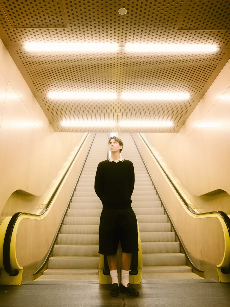 Senior standing at the top of a warm-lit escalator in Seattle