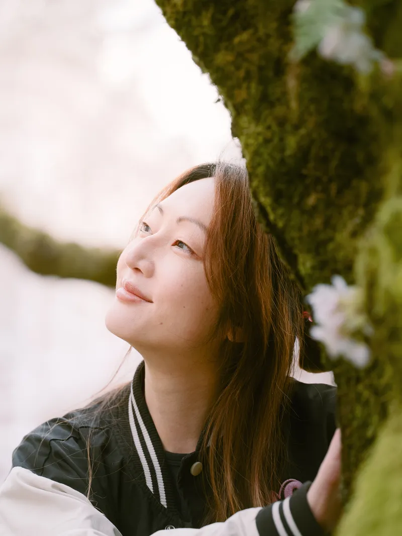 High school senior looking up among spring cherry blossoms in Seattle