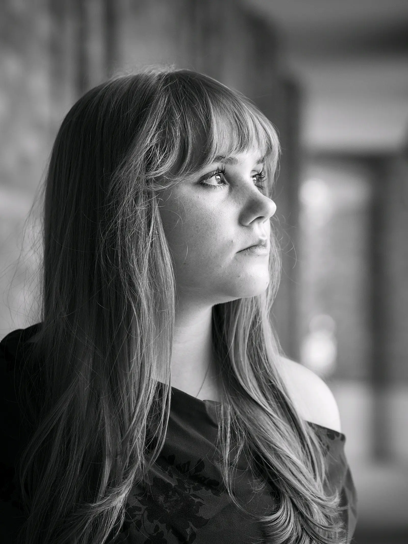 Black-and-white senior portrait against a dark studio background
