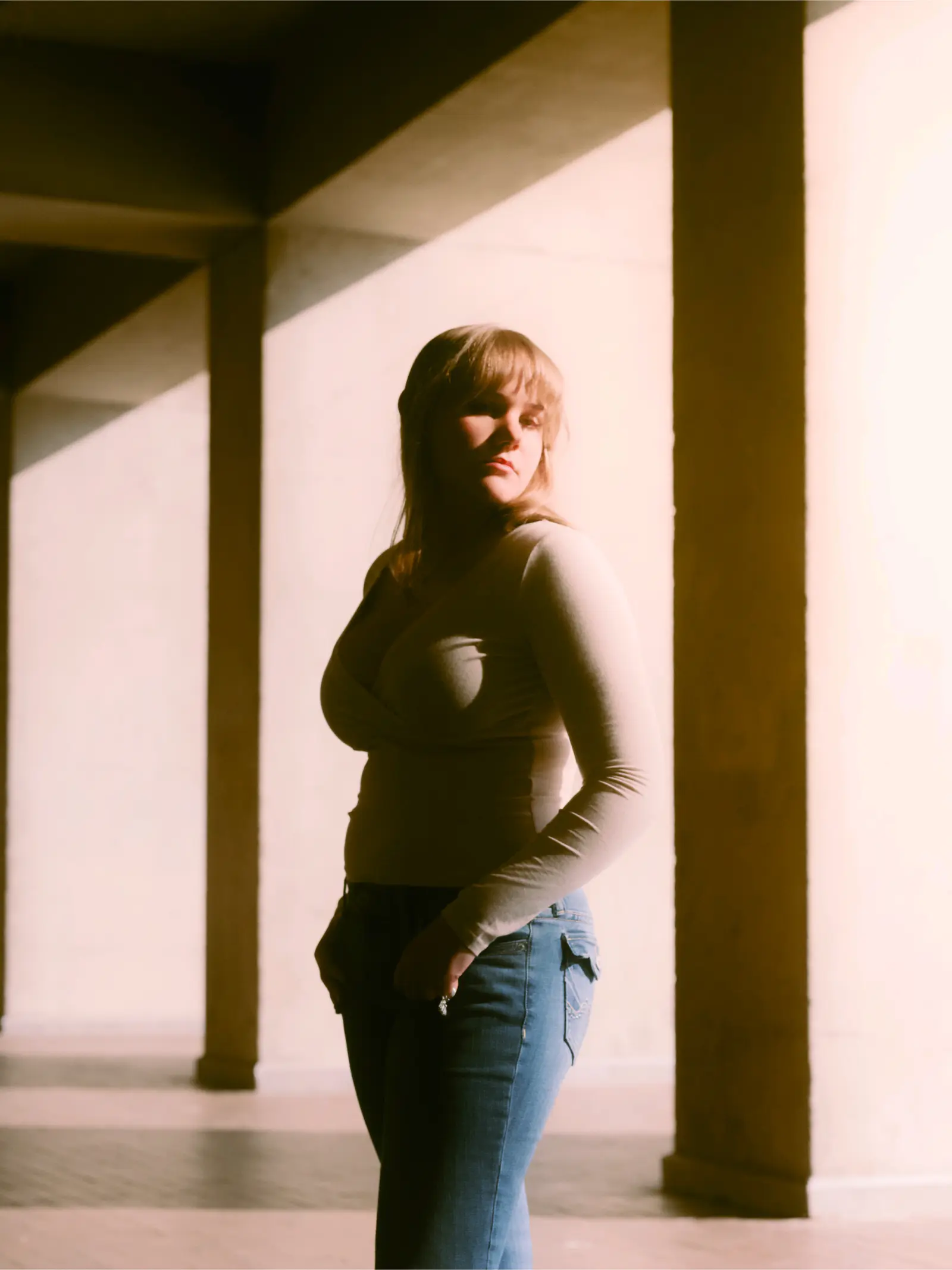 Senior portrait beside modern concrete architecture